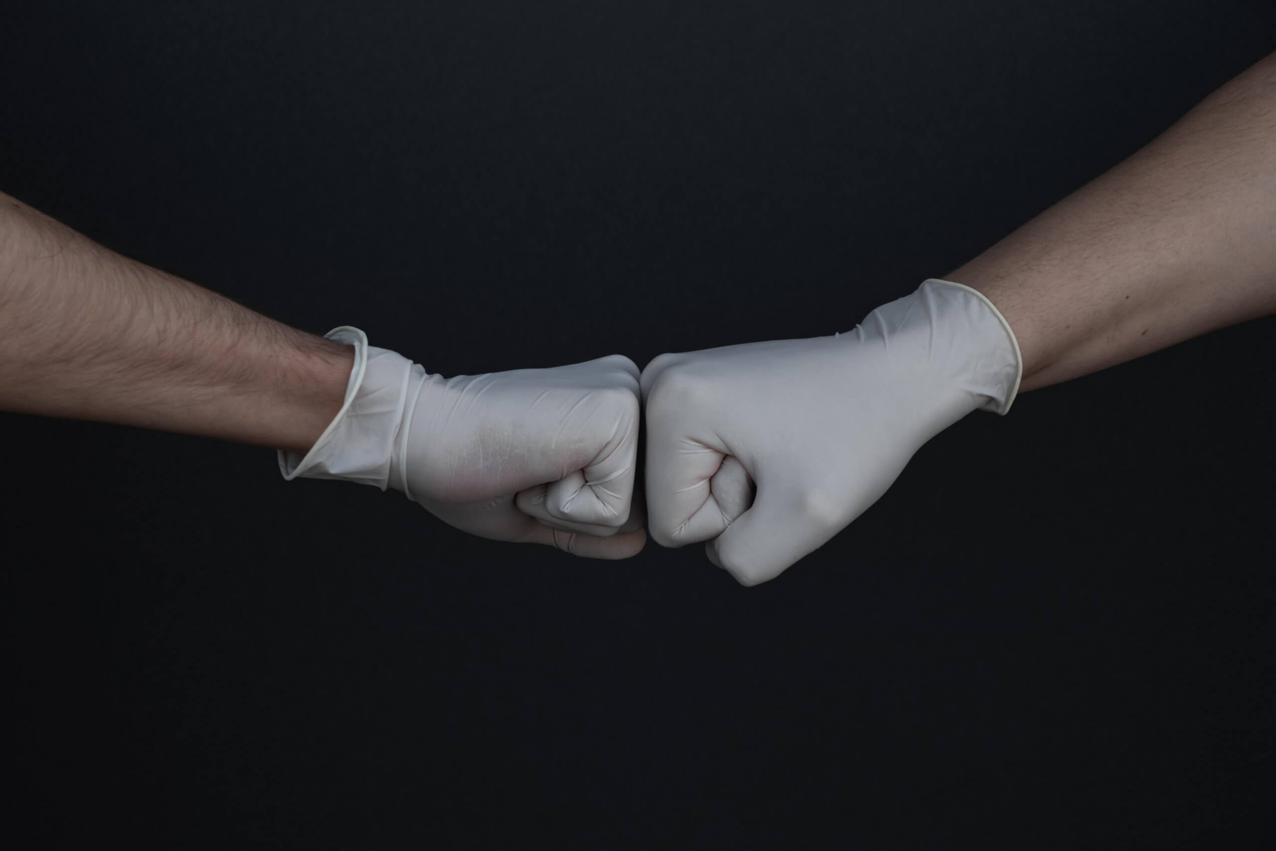image of two gloved hands fist bumping